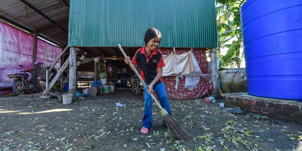 Arunny sweeping the yard with a large broom