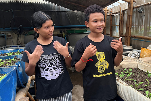 Makara and a fellow student signing in the garden