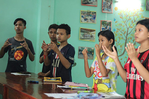 Students in a classroom learning sign language