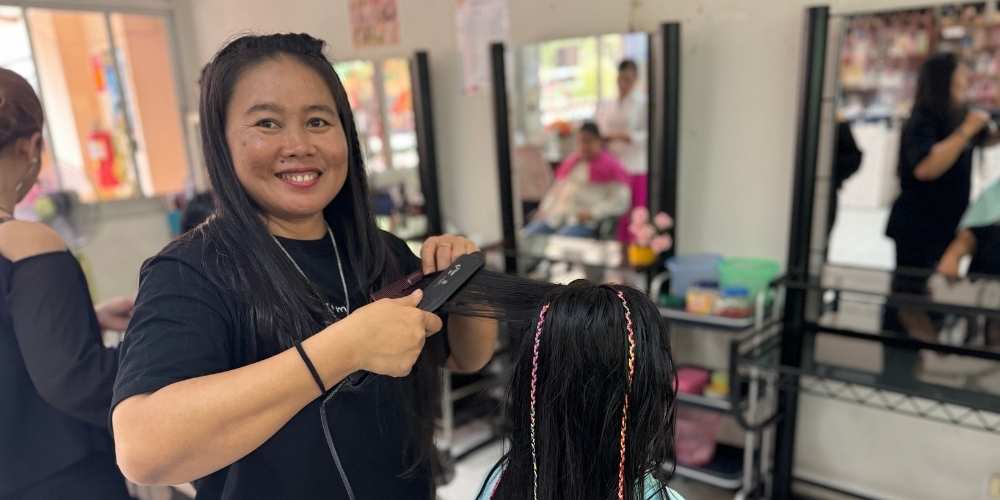 Chantrea putting her new hairdressing skills into practice in a hair salon.