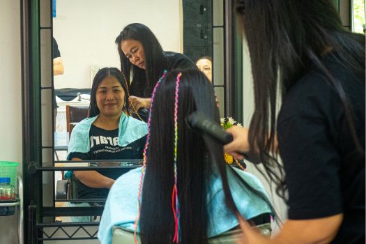 Chantrea and her customer reflected in the mirror of the hair salon