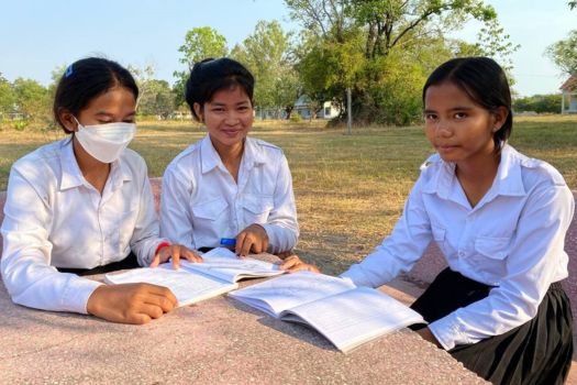 Maly with two of her classmates working outside in the park on a sunny day